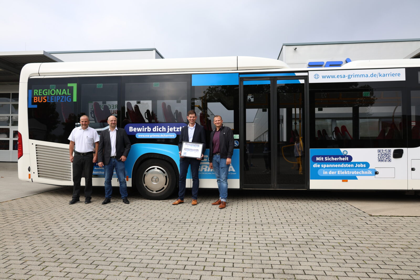 Geschäftsführer bei der Busübergabe mit desen Werbung darauf