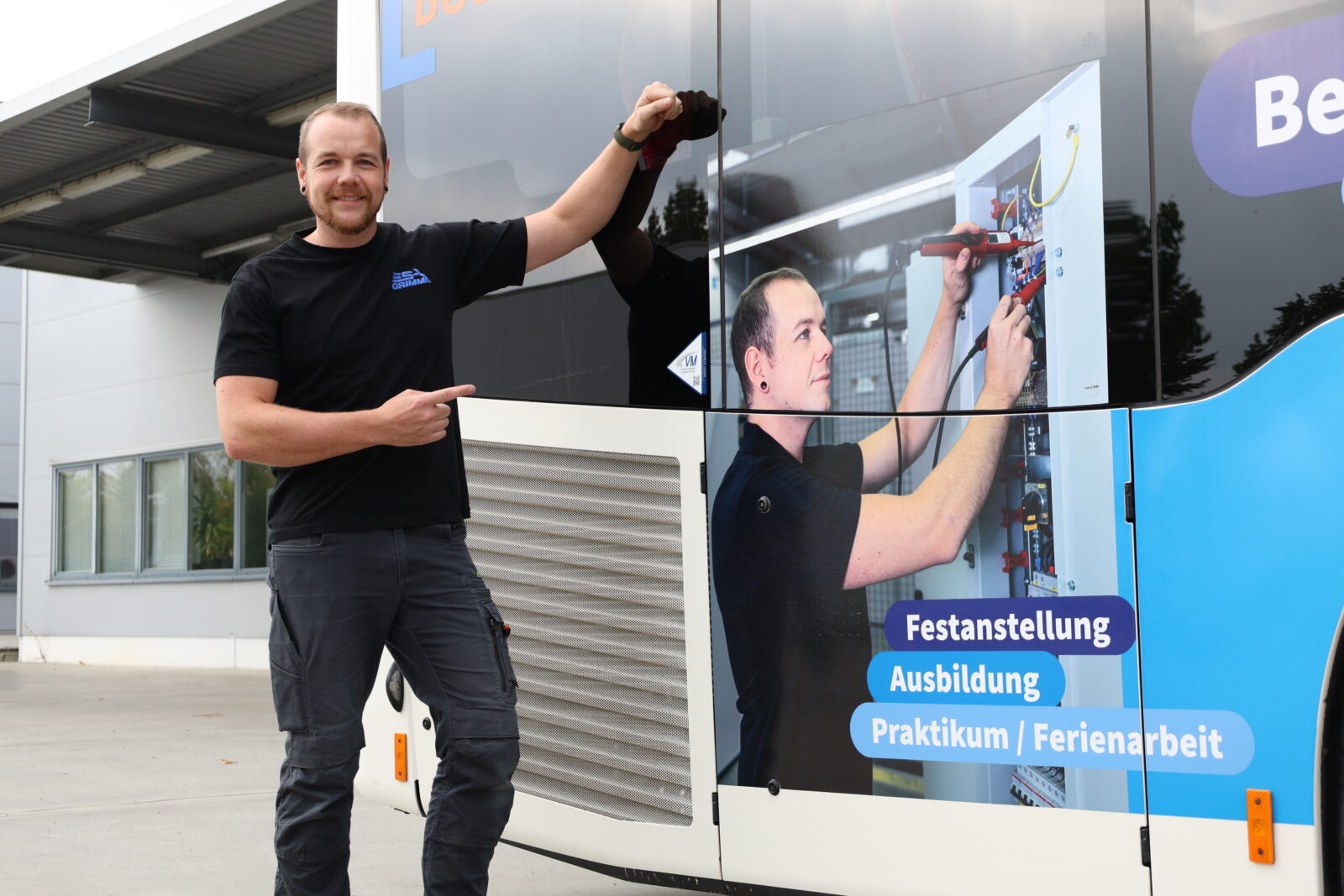 Mitarbeiter von ESA vor der Busfolierung mit seinem Gesicht darauf