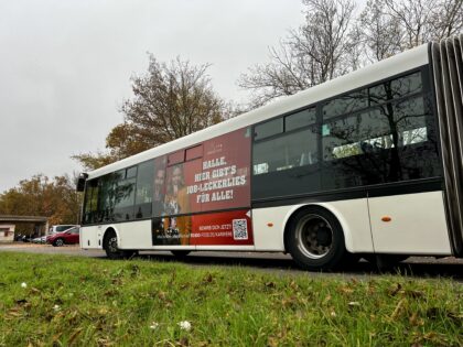 Seitenansicht eines Busses mit einer roten Werbefläche