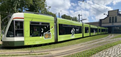 Seitenansicht einer grünen S-Bahn, die aus einem Gebäude herausfährt