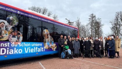 Mehrere Personen stehen vor einem Bus